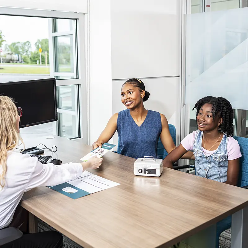 Mom and teen daughter opening checking account at a branch