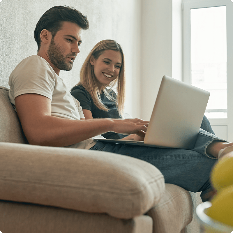 Couple on sofa looking at laptop
