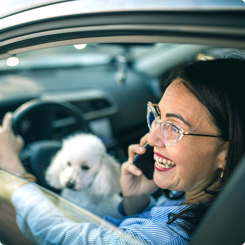 Female member driving car with dog