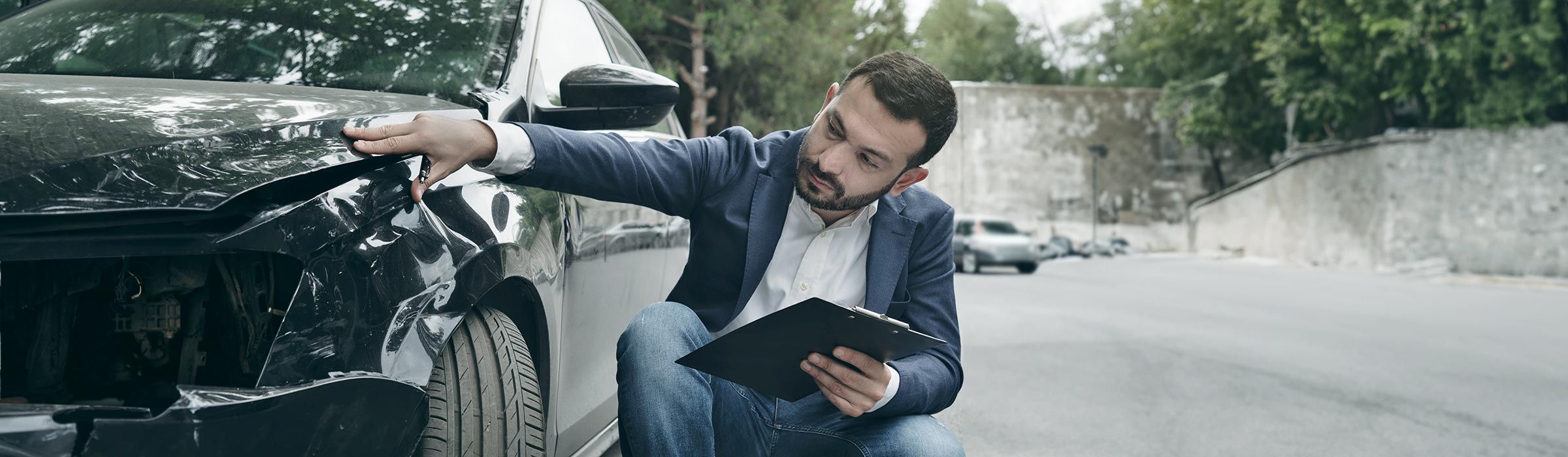 A man looking at his car after an accident