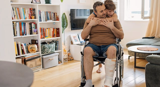 A son hugging his dad in a wheelchair